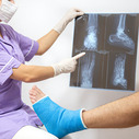 Bone fracture foot and leg on male patient being examined by a woman doctor in a hospital.